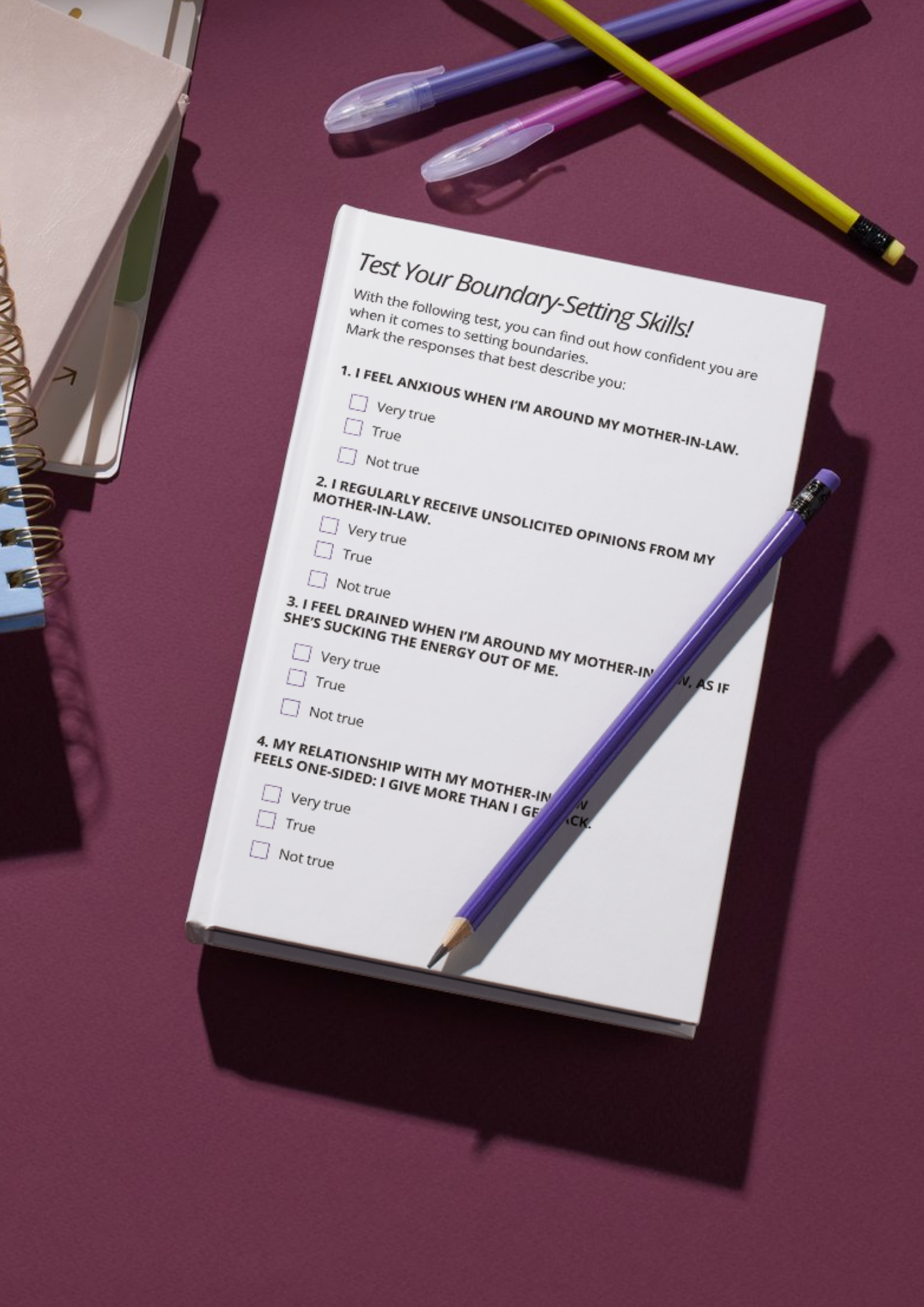 A white paper titled 'Test Your Boundary-Setting Skills!' with a four-question survey about feelings and interactions with mother-in-law, resting on a purple surface with a purple pencil on top and other stationery nearby.
